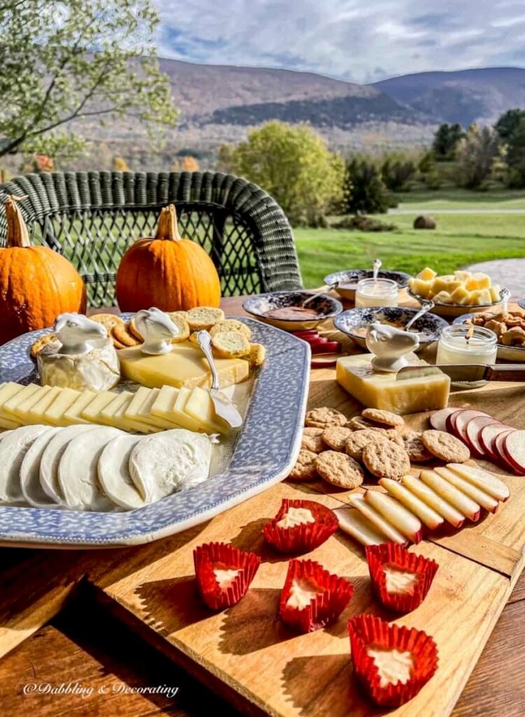 Outdoor table with cheese board and platter with pumpkins and mountain view in Vermont.