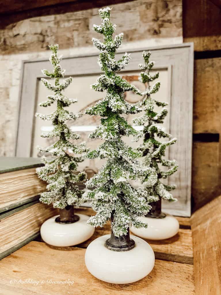 Small Christmas trees in old white doorknobs on display at Vintage Market Days Vermont