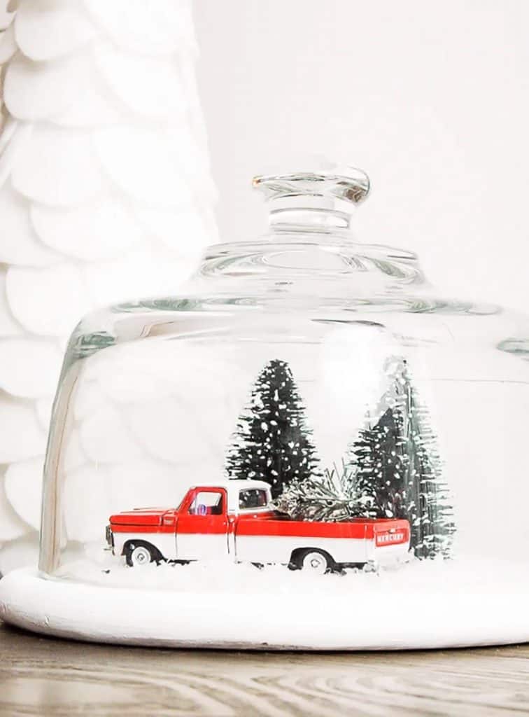 Christmas DIY crafts scene with vintage red truck winter scene under glass chloche