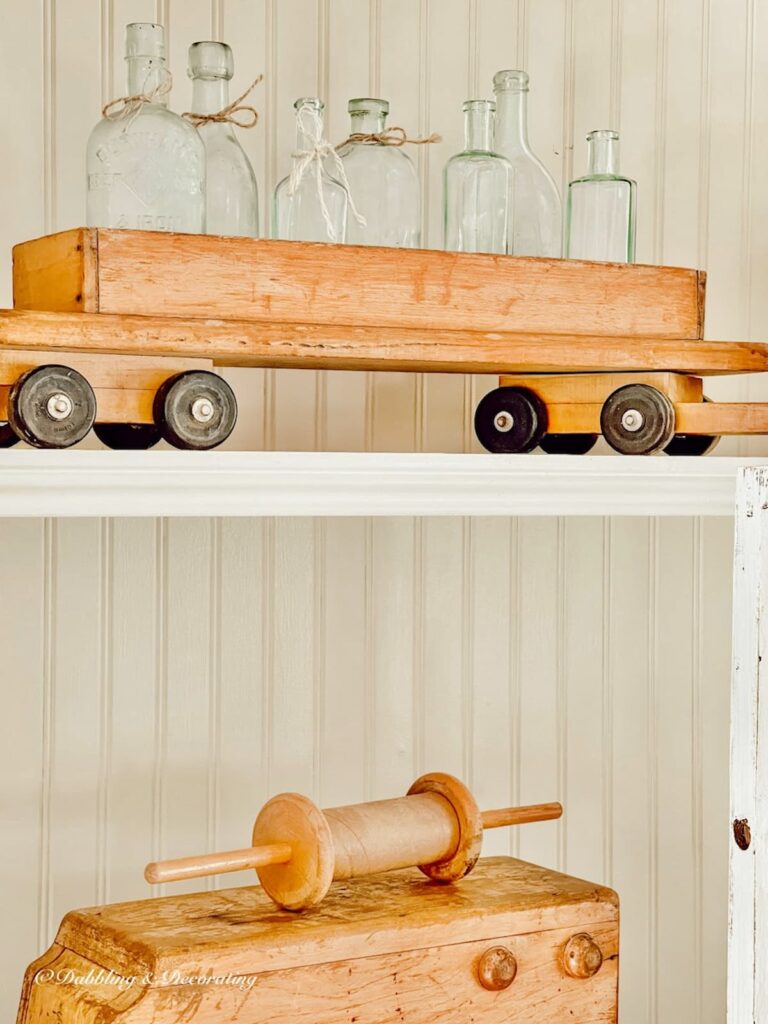 Vintage Wooden Train Set with Bottles and Kite Holder on Shelves
