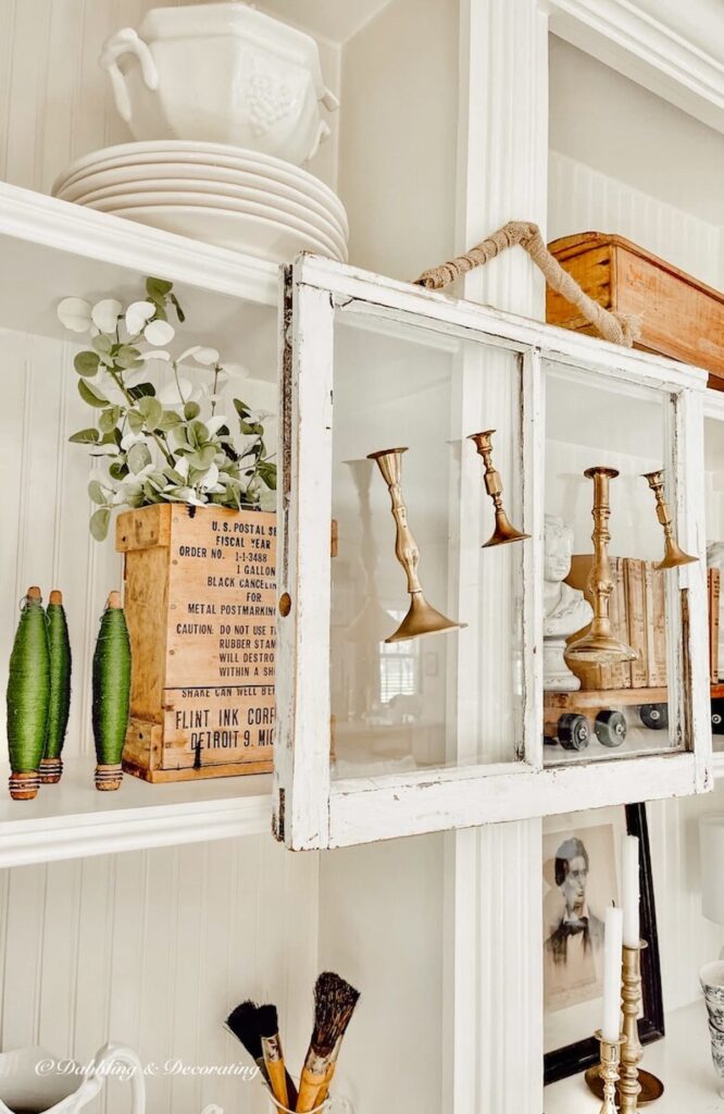 Salvaged Windows with candlesticks hanging from fireplace built ins