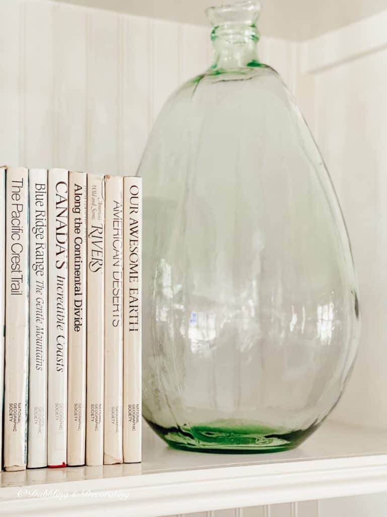 Large Blue bottle with books on fireplace built-ins