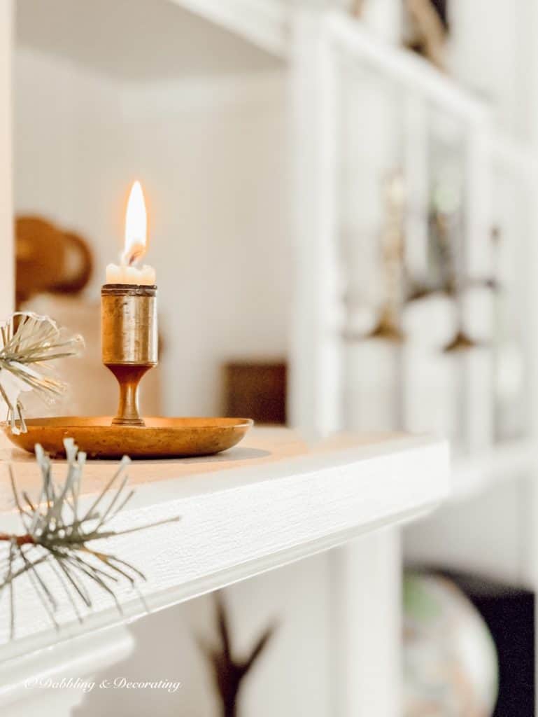 Candle on cozy ski lodge fireplace mantel