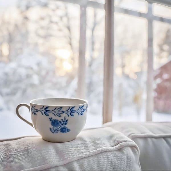 blue and white coffee mug in snowy window interior Swedish home.