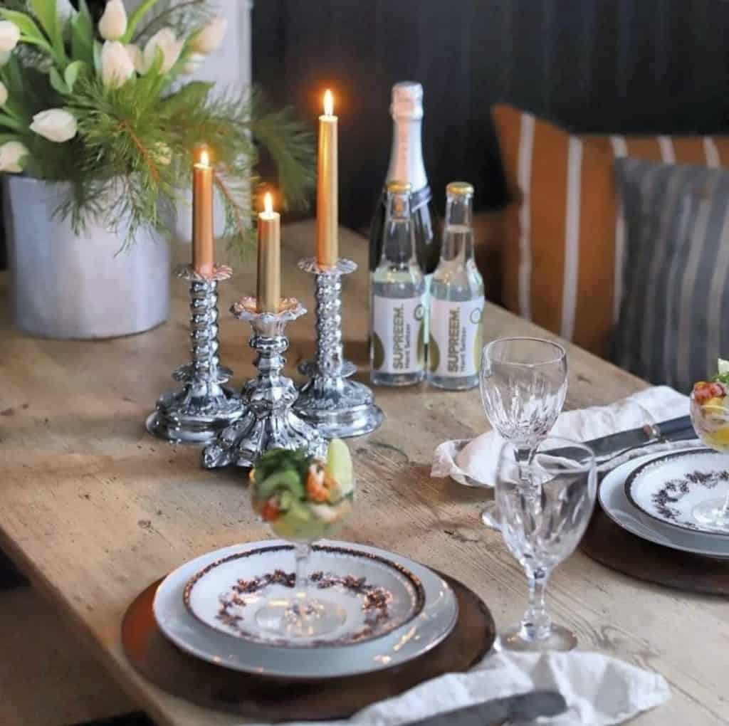 Swedish Homes Dinner Table set so cozy with silver candlesticks, and  simple dinnerware.