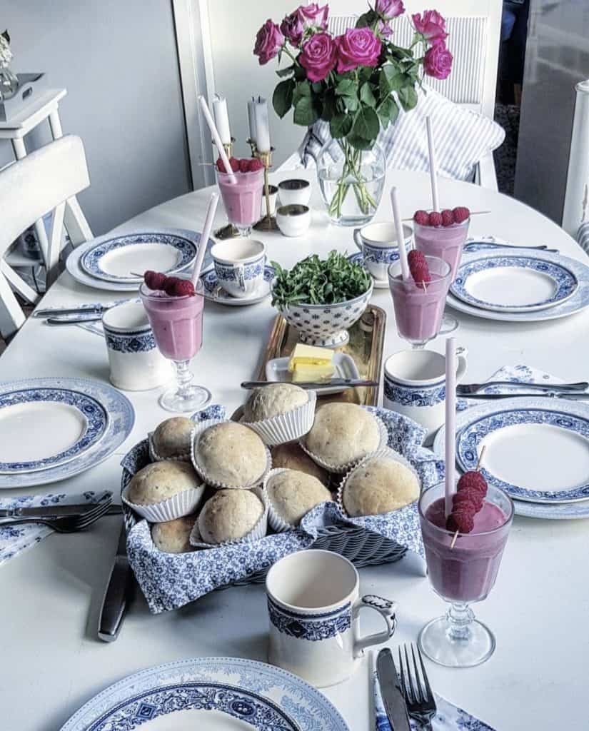 Blue and White Swedish styled Table with biscuits and purple drinks.