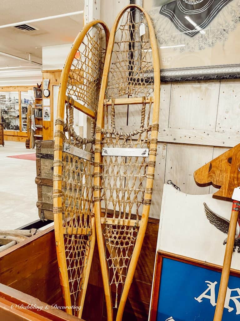 Pair of vintage wooden snowshoes in bin at antique store.