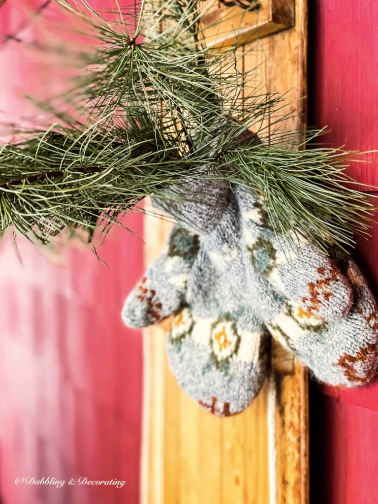 Vintage gray hand knit mittens with evergreens on vintage wooden sled decor.