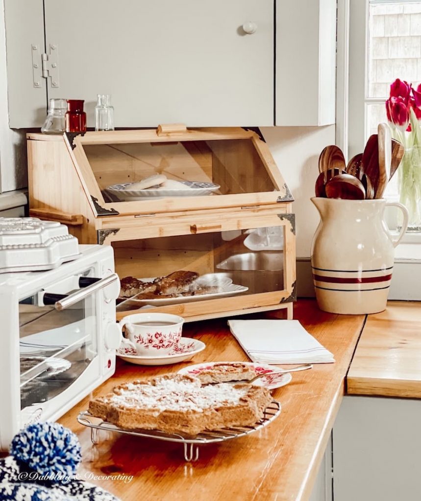 Country Kitchen Counter Decor Ideas with wooden utensils, breadbox, shortcake, and more.