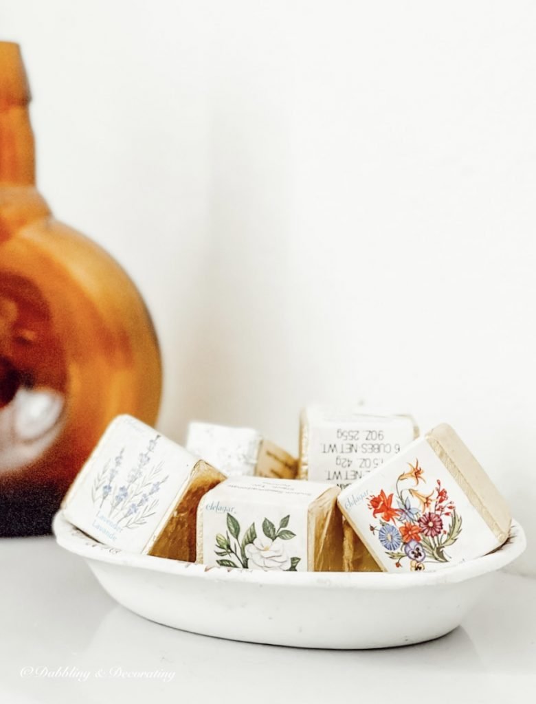 Antique soap dish with old fashioned soaps on bathroom counter.
