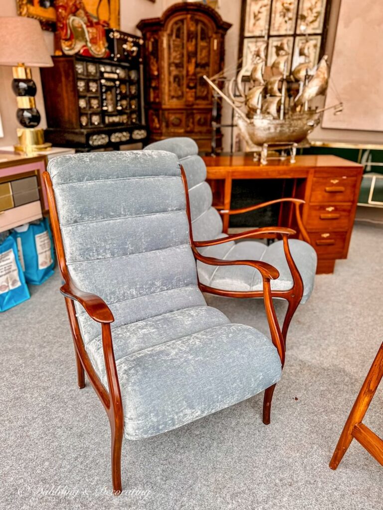 Mid Century modern chair with blue velvet and wood at flea market in Paris.