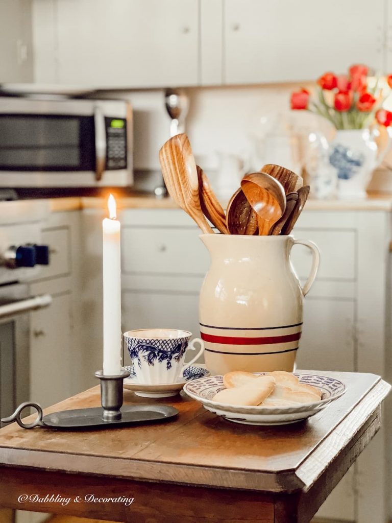 Wooden kitchen utensils in vintage crock on old table.