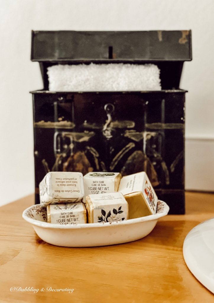 Antique soap dish with old fashioned soaps on bathroom counter.