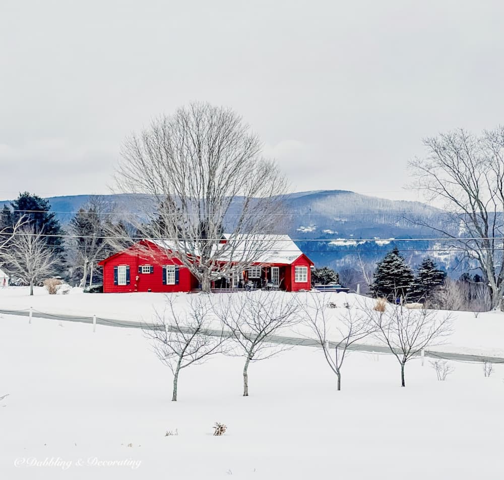 A red house in a snow covered field.