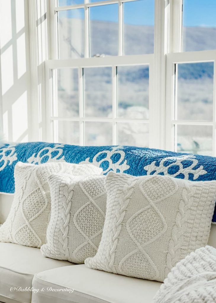 Blue and White Quilt collection in sunroom.