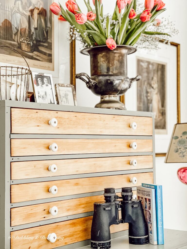 Vintage hutch styling ideas in sunroom with flower arrangement and family heirlooms.