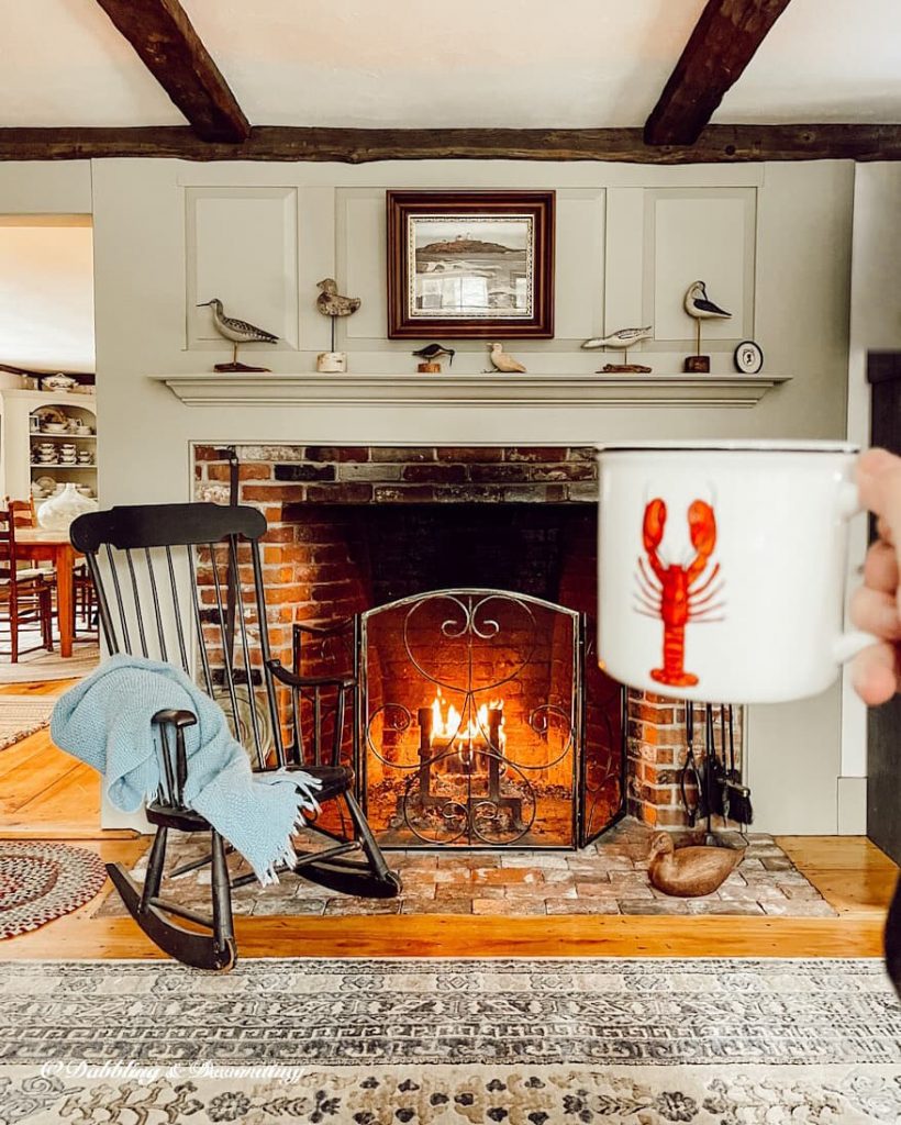 Lobster Mug in hand in front of the fireplace.