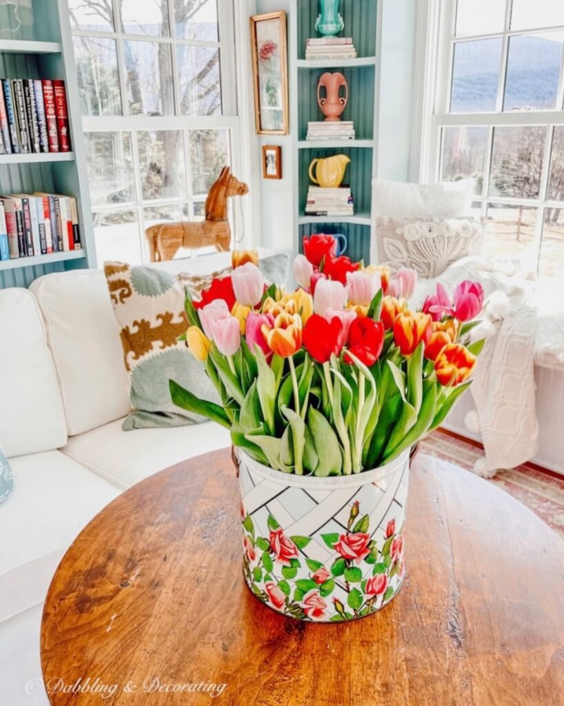 Bucket of colorful tulips in colorful craft room.