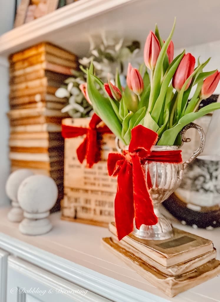 Pink tulip arrangement idea with red ribbon in silver vintage pitcher.