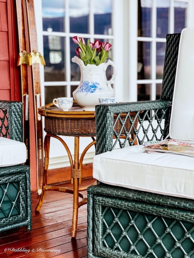 Vintage Wicker side table with dishes and green wicker furniture.