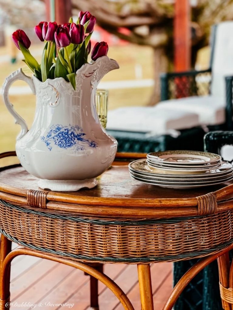 Vintage wicker furniture side table with dishes and tulips