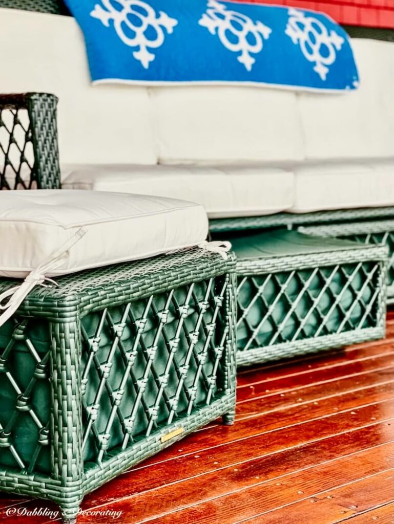 porch furniture ideas with green wicker couch and ottoman with storage drawers, white cushions from Ballard Designs on covered porch with blue quilt.