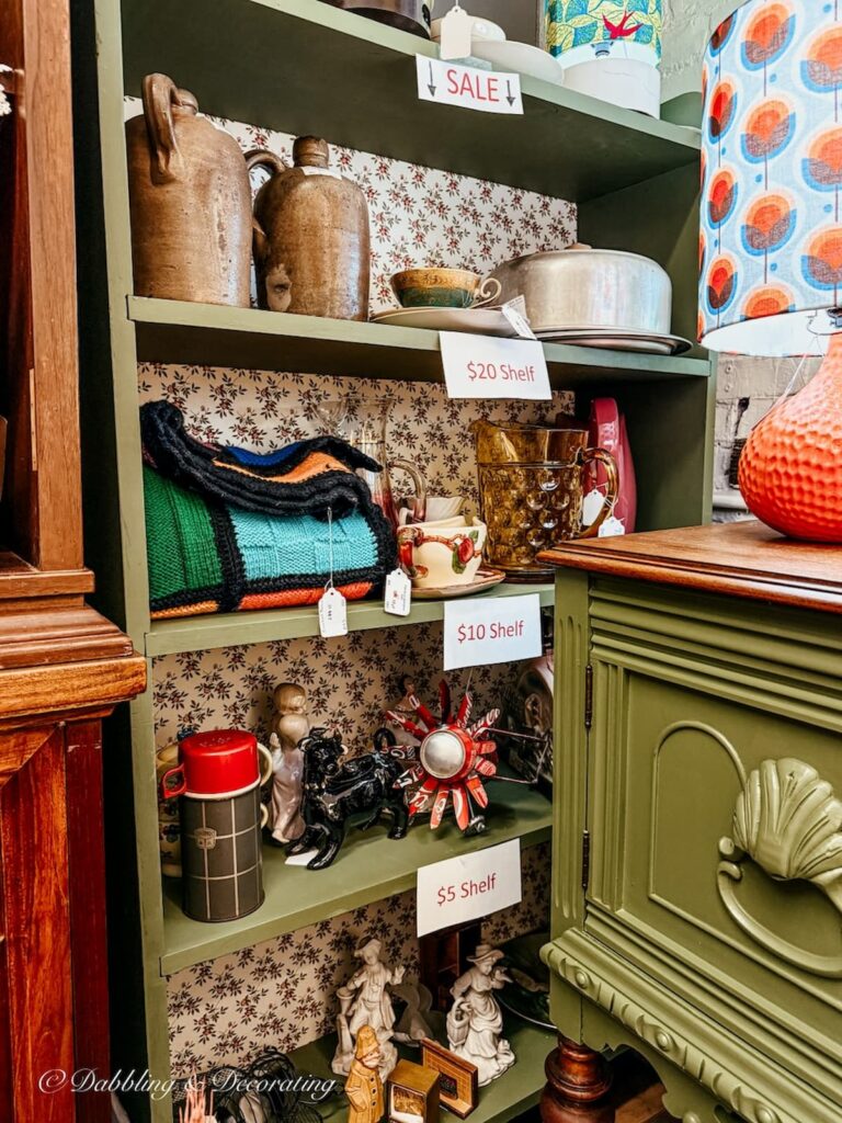 Vintage booth with discounted signs on shelving.