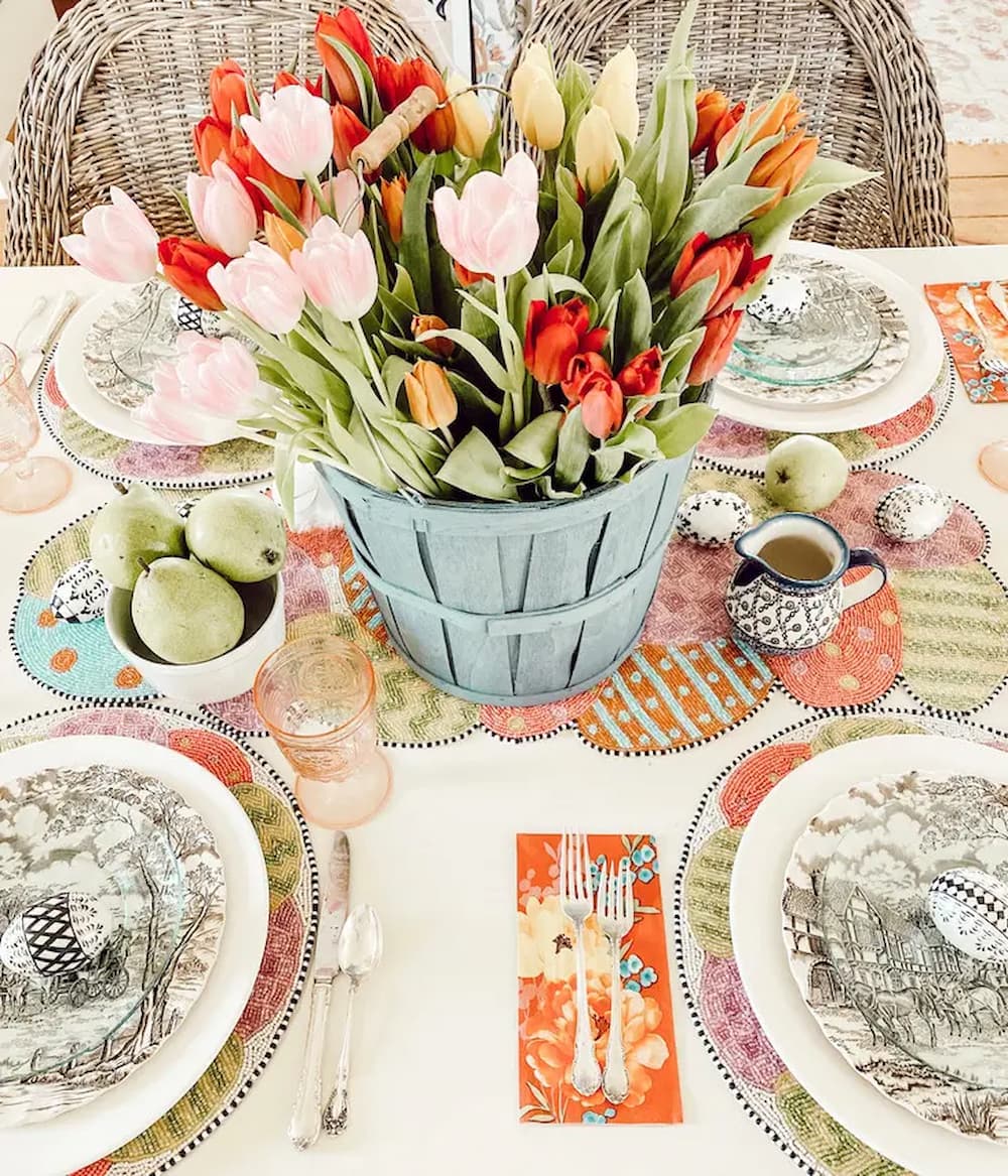 Colorful spring tulips in blue bucket on Easter table.