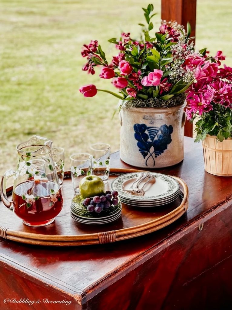 Antique crockery on porch with spring pink flower bouquet.