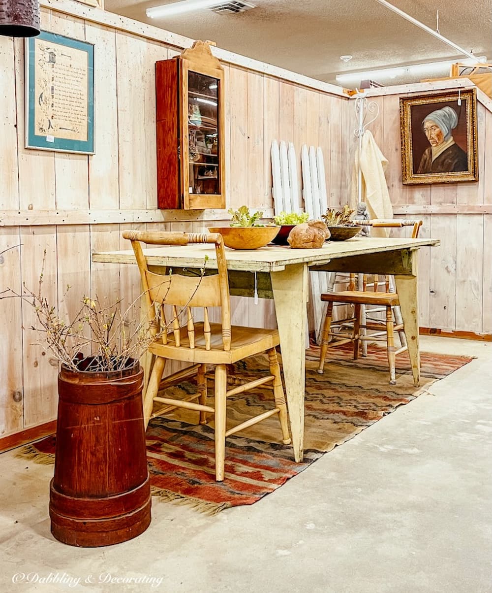 Antique table with two yellow chairs displayed in antique booth at Stone House Antique Center.