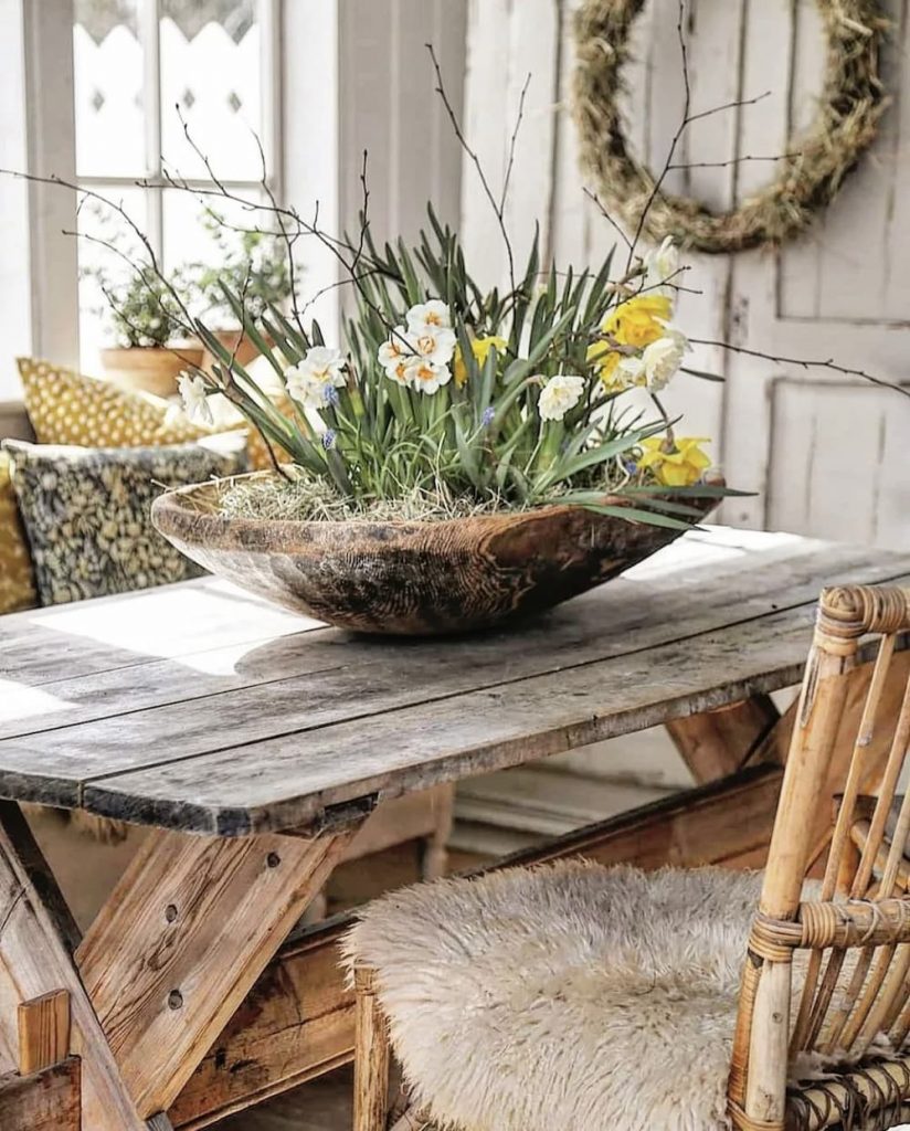 A thrifty home decor featuring a wooden table adorned with a beautiful bowl of flowers.