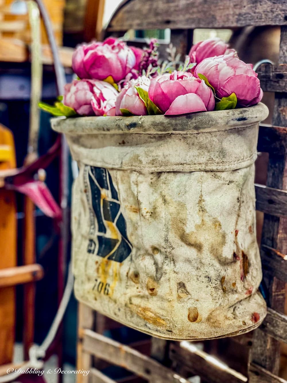 Pink faux peonies in a vintage hanging bag.