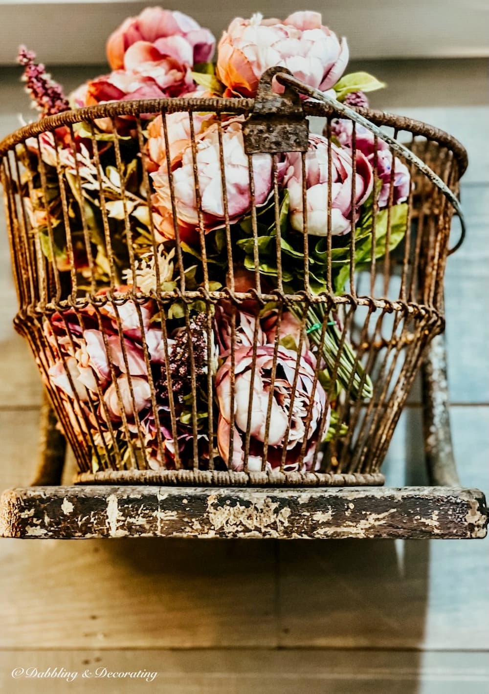 Pink peonies in a rustic basket on shelf.