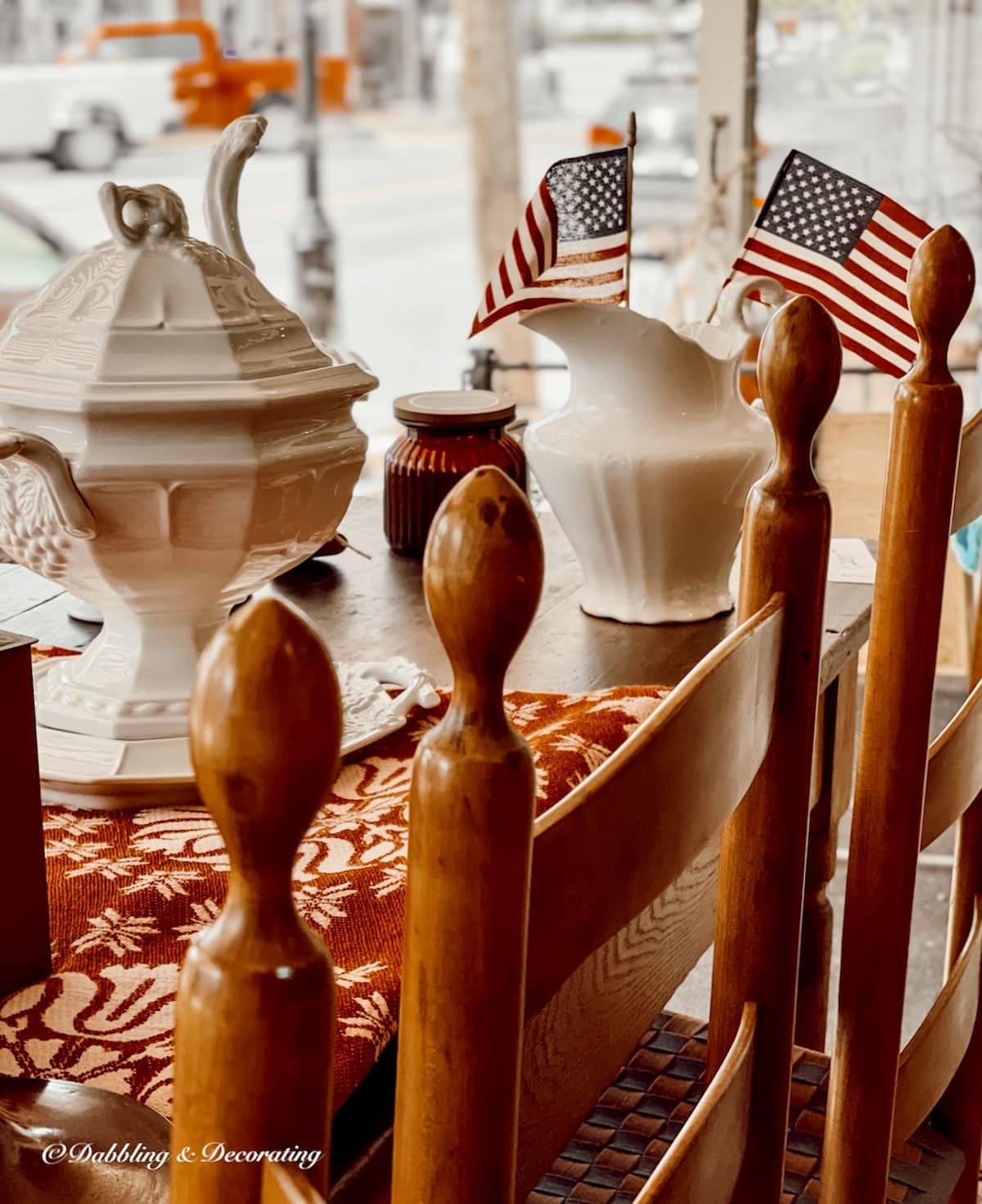 Vintage table and chairs with white ceramic soup tureen and pitcher with American flags for vintage Americana decor ideas.