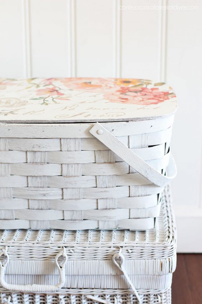 White vintage picnic basket with rose colored flowers.