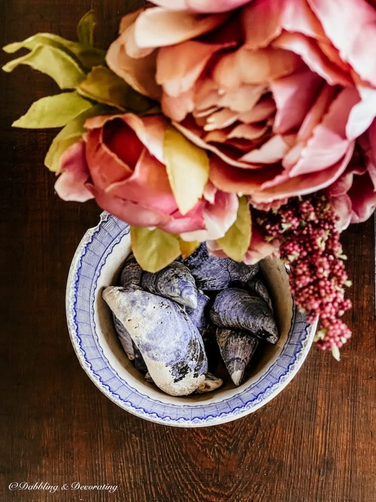 Vintage Coastal bowl of blue mussels on coffee table with faux peonies.