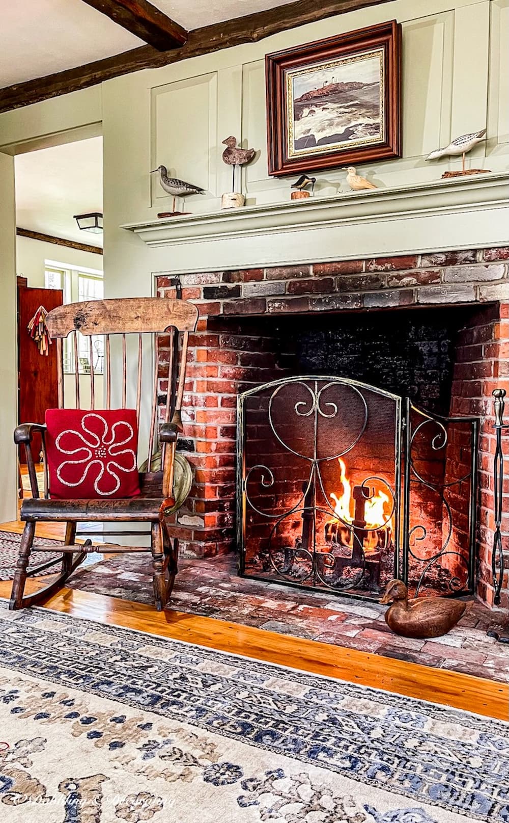 Antique Boston Rocker Chair in front of colonial fireplace with red pillow.