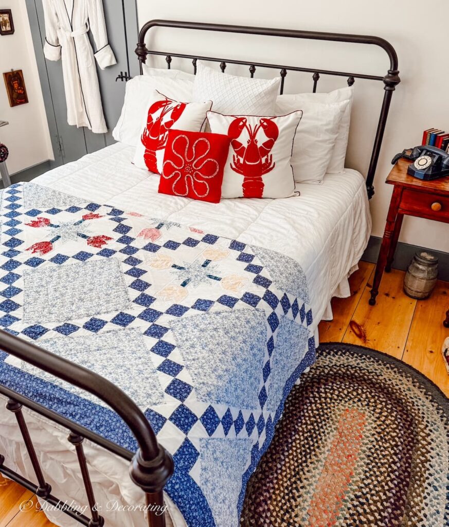 Small guest bedroom with wrought iron bed, braided rugs, quilt and vintage Americana decor ideas.