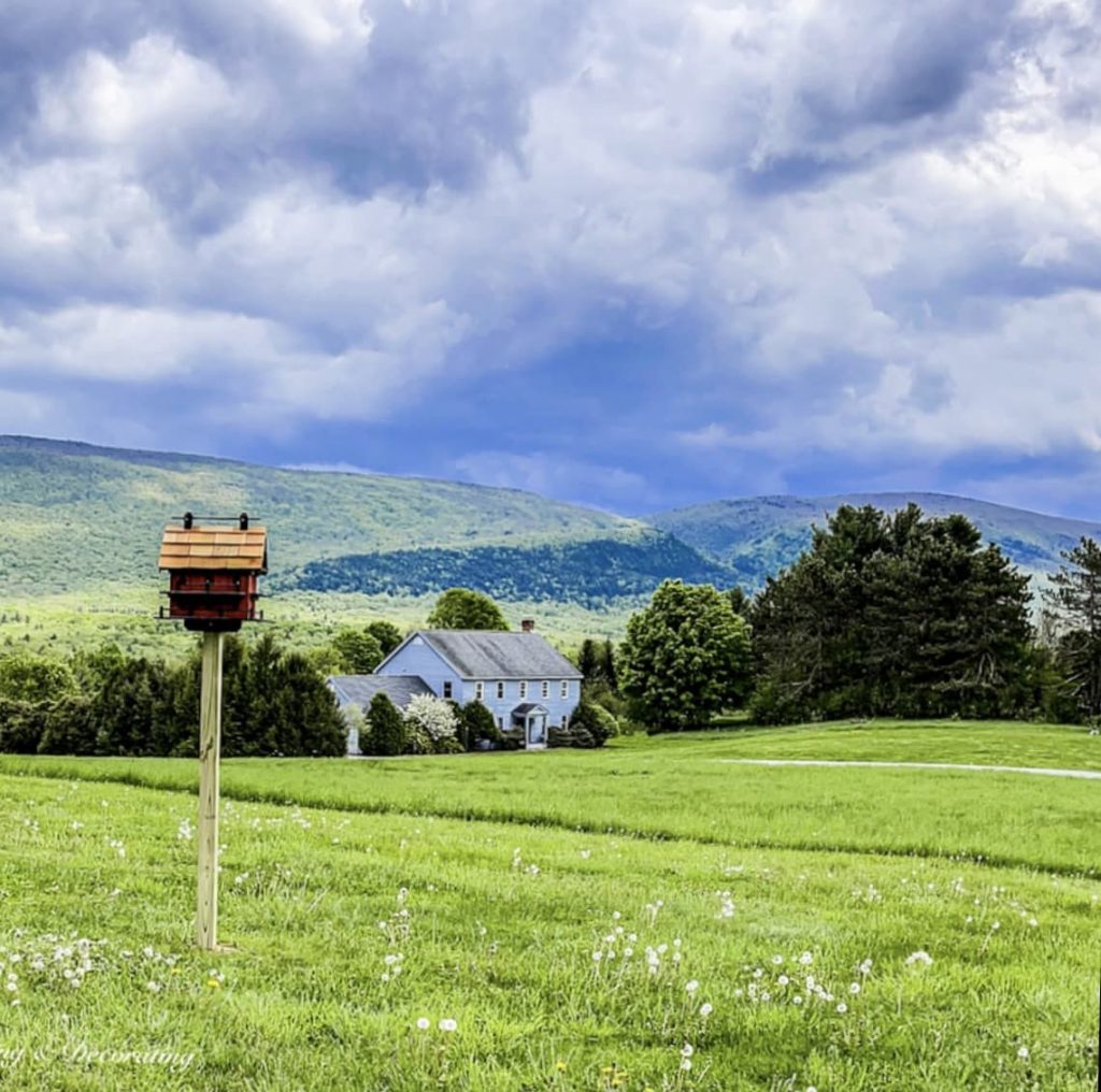 Large red burgundy red Amish birdhouse mounted in the mountains of Vermont.