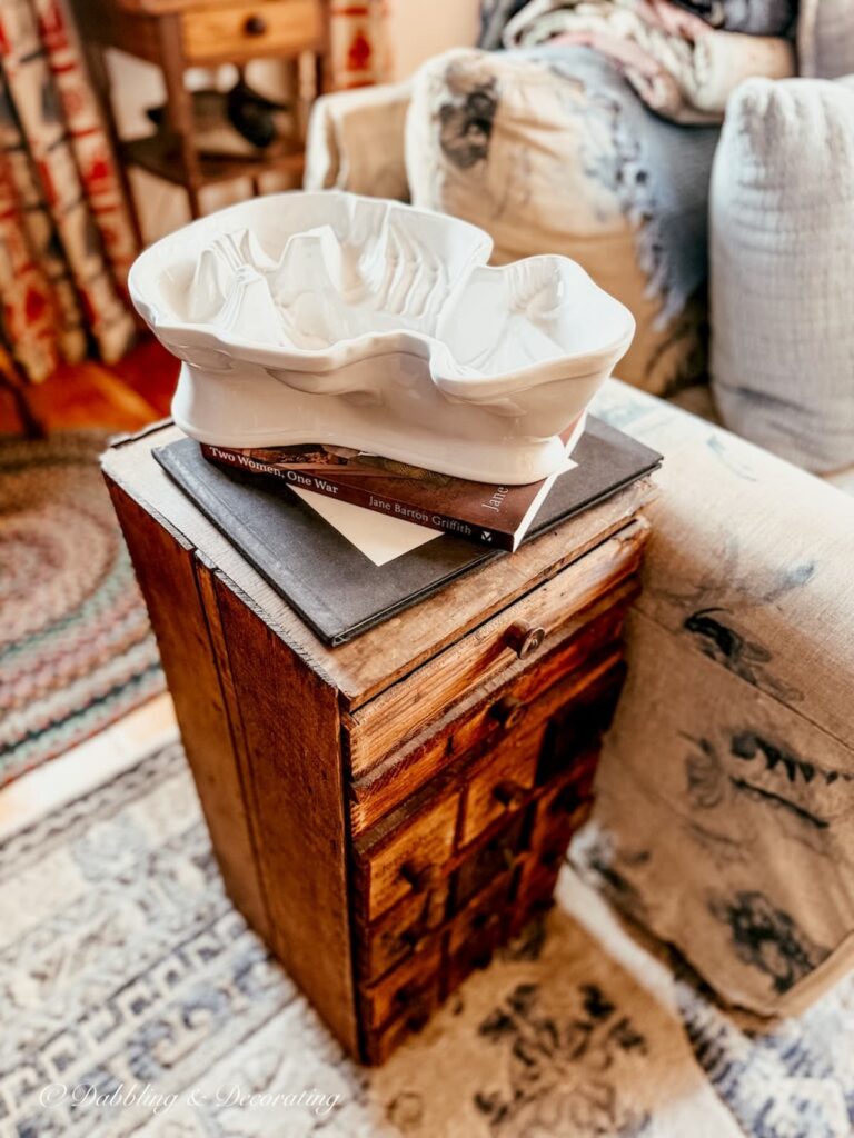 Wooden small antique apothecary chest in coastal grandmother decor with an ironstone lobster mold found antiquing.