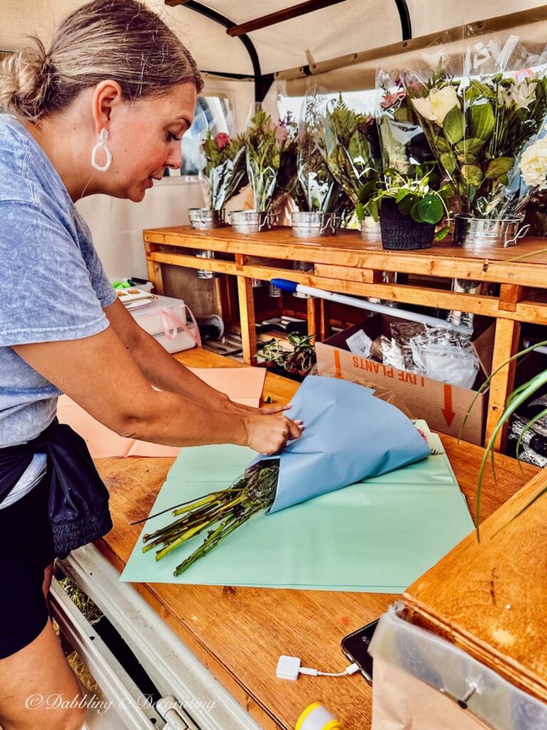 Girl wrapping summer flower bouquets at Vintage Bazaar New England