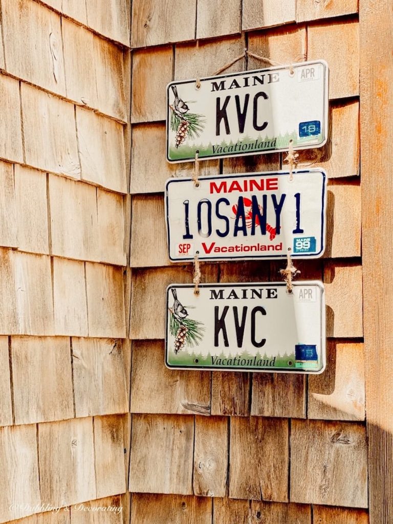 DIY License Plate Wall Decor on Cedar Shake Home.