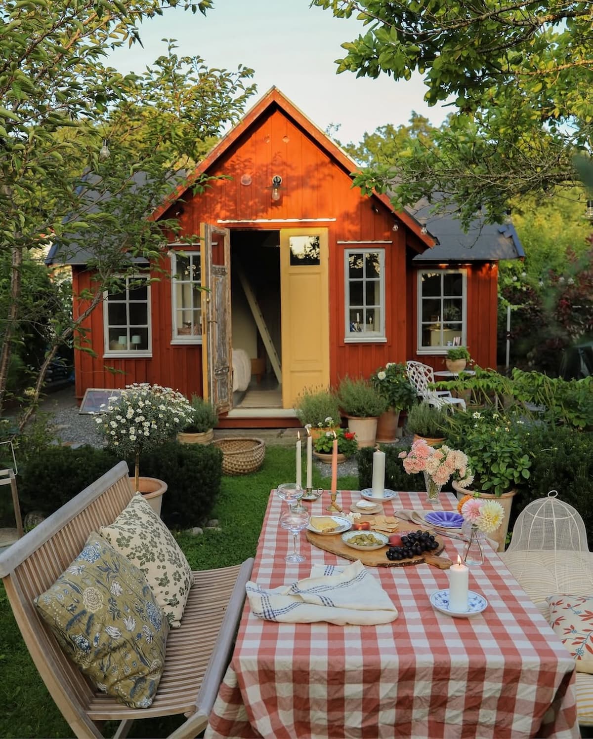 Scandinavian cottage style, red house with outdoor alfesco table setting in Sweden.