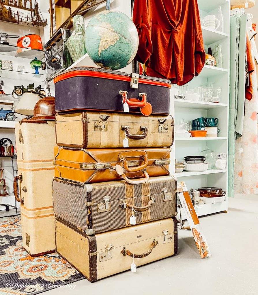 Vintage suitcases piled up in thrift store.