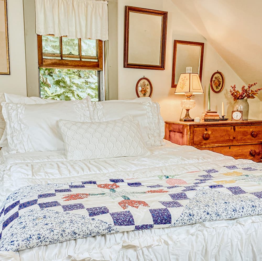 A cozy bed in a bedroom with a beautifully decorated quilt on it.