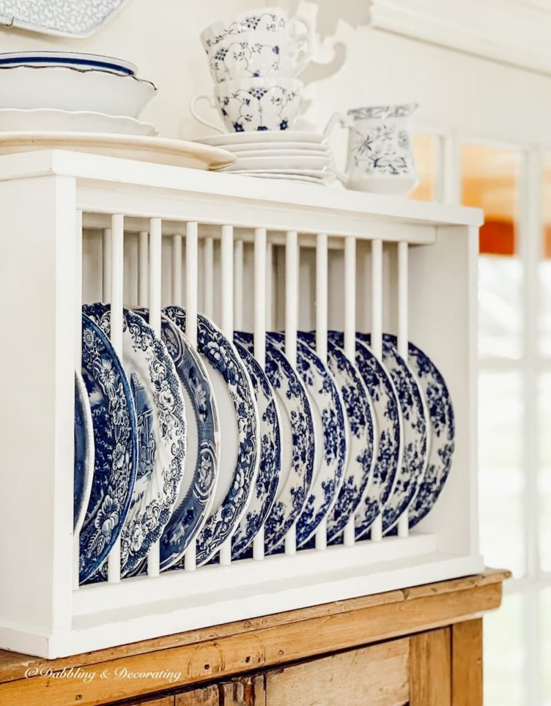 Display of blue and white dishes in kitchen wall rack.