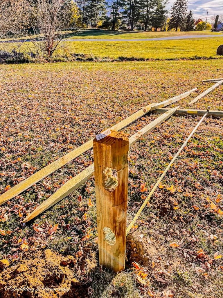 Split rail fence layed out on lawn.