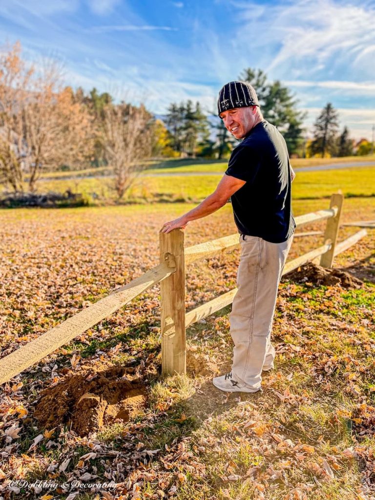 Man next to split rail fence.