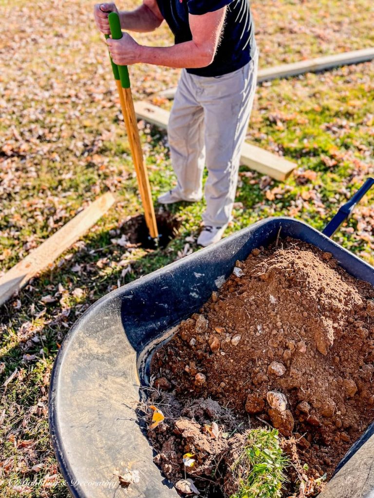 Man digging hole designing a fence.