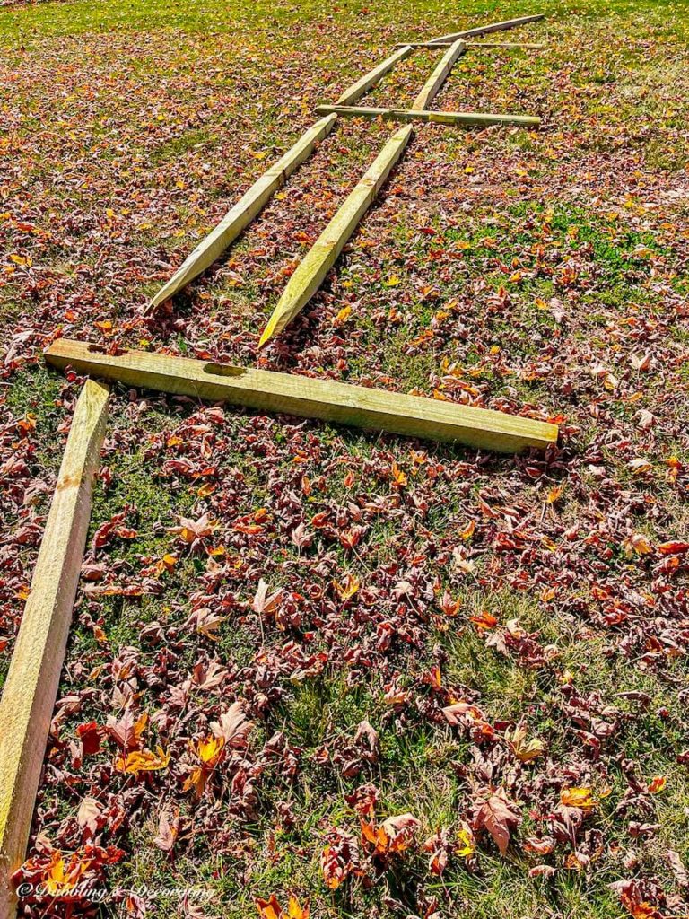 Split rail fencing layed out on lawn.